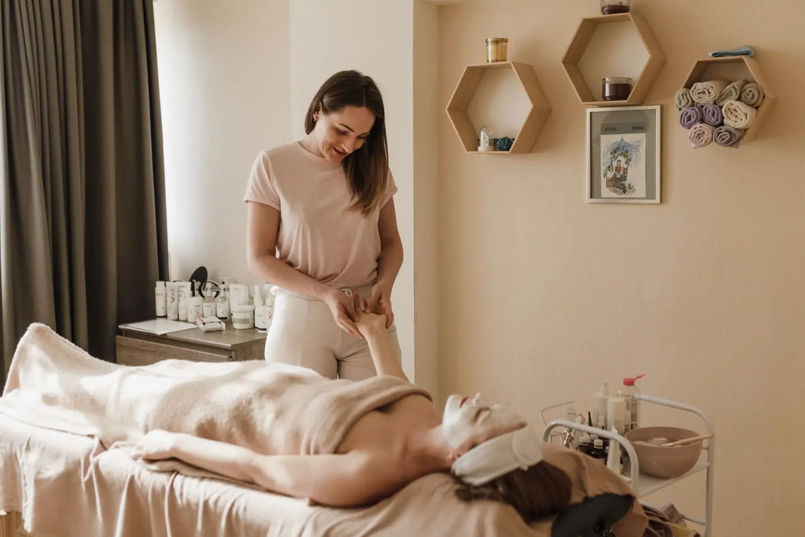 Praticienne réalisant un massage à une cliente allongée sur une table de soin